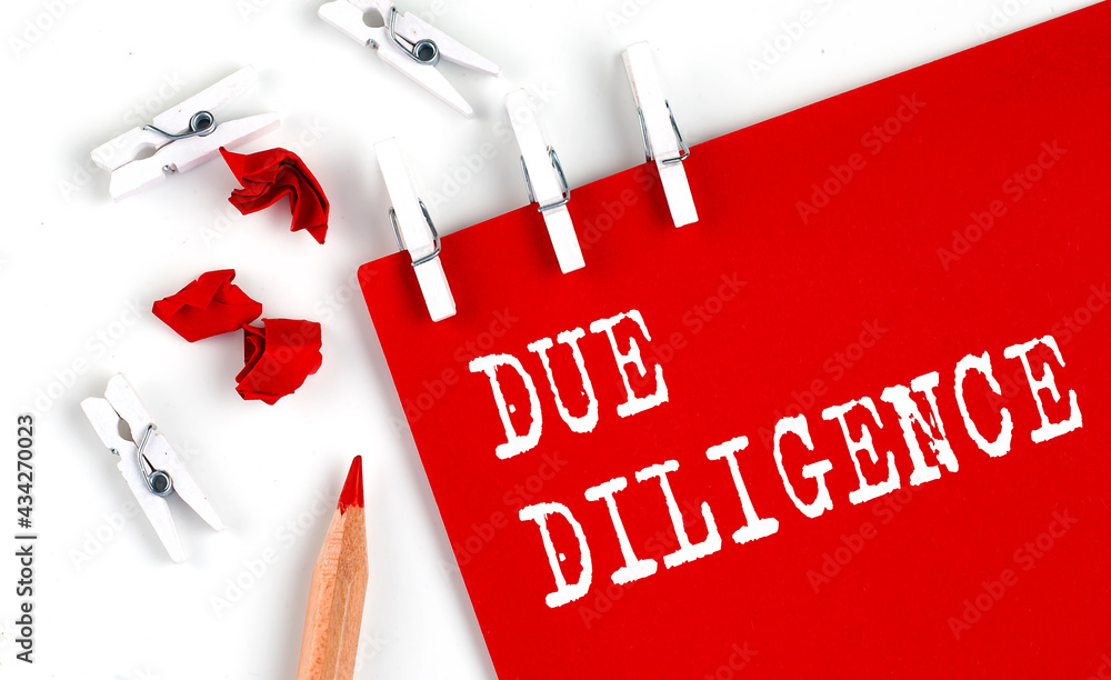 Poster due dilligence text on red paper with office tools on white background