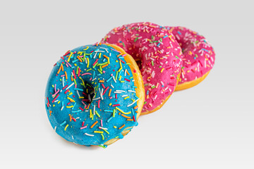 Donuts with blue and pink frosting, sprinkled with colorful crumbs