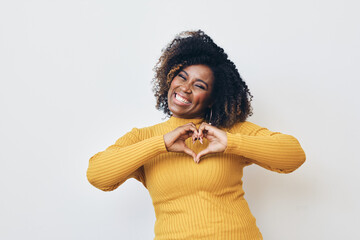 Happy African-American woman making heart with hands - Powered by Adobe