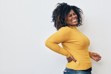 Profile Woman grimacing while struggling with backache against a white background