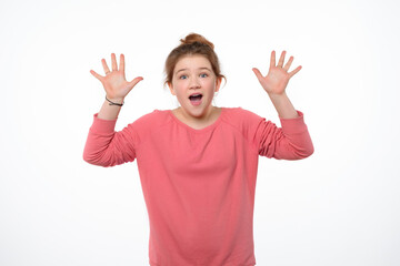 What wonderful news. Surprised and happy young girl express overjoy and surprised, spread hands sideways