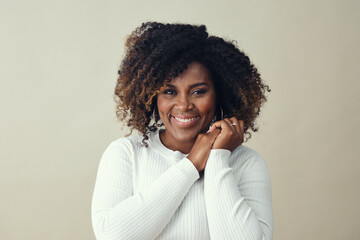 Beautiful smiling African American woman in her 30's with hands clasped looking at camera 