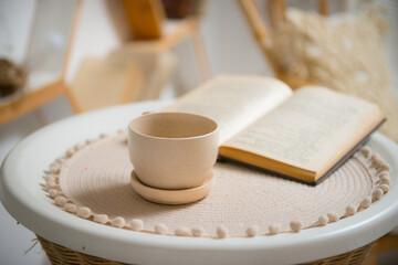 Obraz na płótnie Canvas Clay cup and saucer on a rattan curbstone. Close-up.