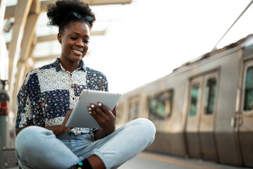 Young woman holding digital tablet. Beautiful african woman traveling around the city.