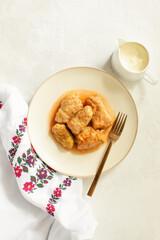 National Ukrainian cuisine dish Golubtsy served with sour cream, top-down view
