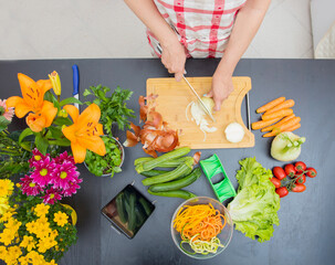 Woman In Kitchen Following Recipe On Digital Tablet