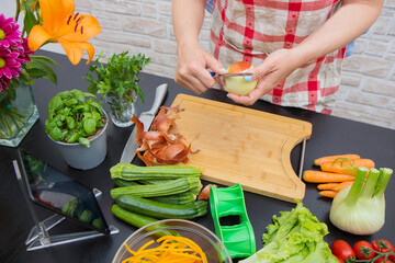 Woman In Kitchen Following Recipe On Digital Tablet