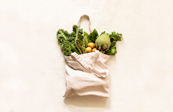 Fresh green produce in reusable shopping bag, top down view