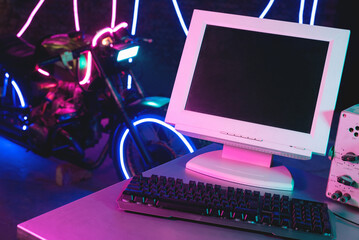 Concept of sci fi motorbike development department. A blank screen computer monitor screen with copy space on the foreground of neon lights motorbike.