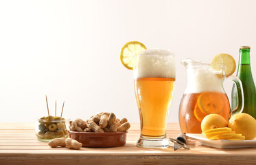 Beer with lemon and snacks on wooden table isolated background