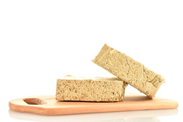 Two slices of vanilla halva on a wooden board, close-up, isolated on white.