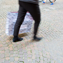 People walking in a pedestrian zone paved in little stone