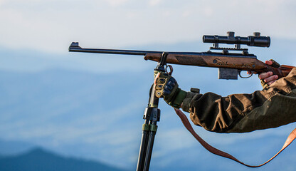 Hunt hunting rifle. Hunter man. Shooter sighting in the target. Hunting period. Male with a gun....