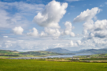 View from Kerry Cliffs on Portmagee village, fields and farms with fiord and mountain range in background, Iveragh peninsula, Ring of Kerry, Ireland