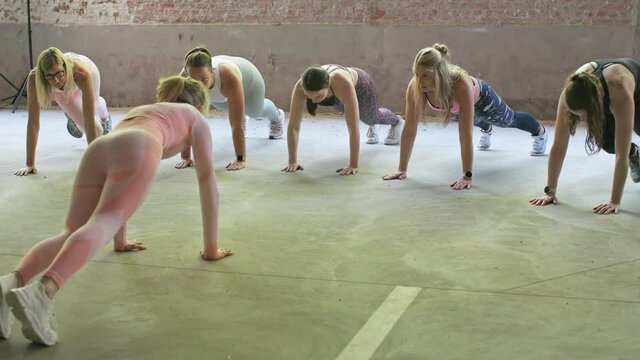 group of women indoors following workout of a female personal trainer giving fitness sport class