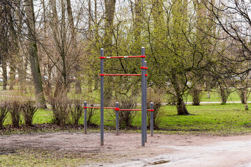 Fototapeta na wymiar An empty gymnastic horizontal bar in a city park in early spring