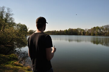 Am Galgenmoor See: Ein junger Mann lässt eine Drohne fliegen  