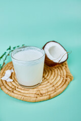Fresh healthy coconut milk in a glass on blue  background, Alternative type of vegan milks, Organic Healthy drink concept.
