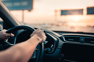 Close-up - Hand of Man driving car at sunlight.