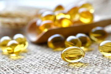 Close up view, Clear yellow vitamin oil in oval shape on sackcloth.