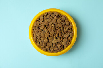 Obraz na płótnie Canvas Pet bowl with feed on blue background