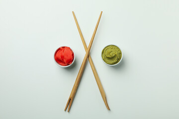 Chopsticks, wasabi and pickled ginger on white background