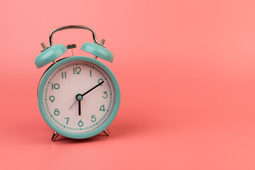 Old clock isolated on a pink background with space for text. Concept of time