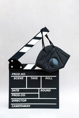Movie clapperboard  and protective face mask. Concept of coronavirus protection at movie cinema...