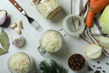 Fresh sauerkraut and ingredients on white textured table