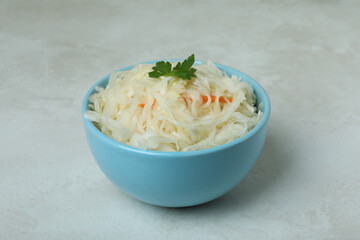 Bowl of sauerkraut on white textured background