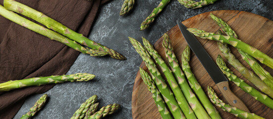 Cutting board with asparagus on black smokey background