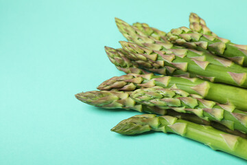Fresh green asparagus on mint background, close up