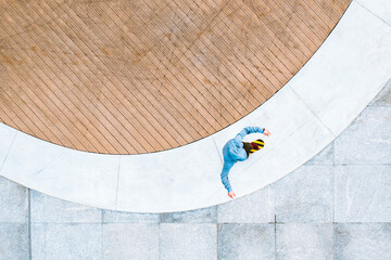 Aerial top down view of skateboarder riding in public area in Kaunas city, Lithuania.