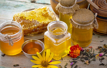 Sweet honey with flowers on an old background.