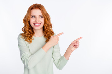 Photo portrait of red haired woman smiling pointing finger empty space dreamy curious isolated...