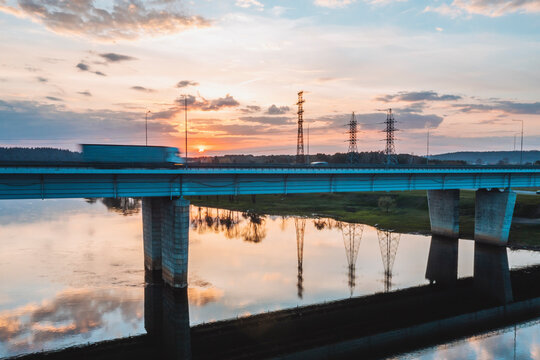 Aerial view of cargo truck driving over the river on highway bridge in Kaunas, Lithuania. - Powered by Adobe