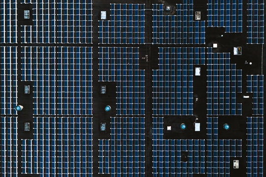 Aerial top down view of solar energy panels park on a factory rooftop collecting green energy from sun in Kaunas, Lithuania.