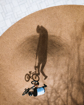 Aerial view of BMX rider silhouette shadow looking like monster creature or circus bear, Panevezys, Lithuania.