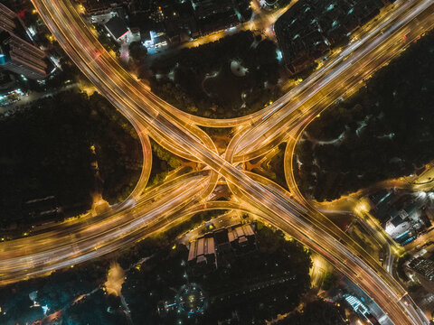 Aerial view of a complex road intersection with vehicles driving on the highway at night, Huangpu District, Shanghai, China.