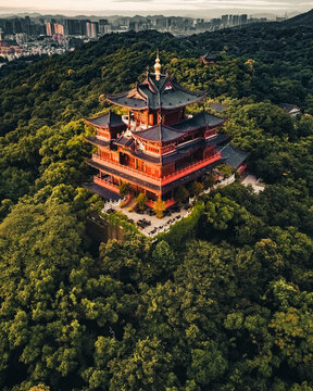 Aerial view of a buddhist temple on the top of the hill in the forest at sunrise, Hangzhou, China.