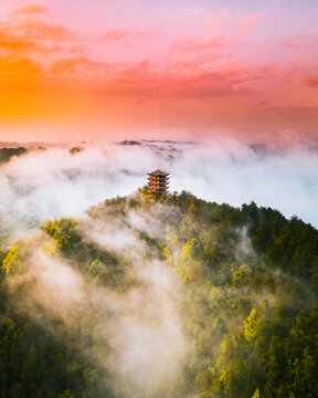 Aerial view of a buddhist temple on hilltop during a foggy day at sunset, China.