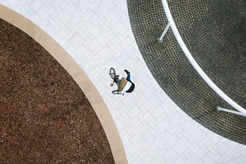 Aerial view of BMX rider doing a trick in public area in city center in Panevezys, Lithuania.