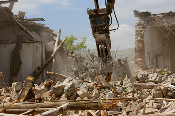 Tracked excavator demolishing old buildings