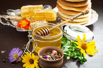 Fototapeta na wymiar Sweet honey with flowers on an old background.