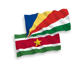 National vector fabric wave flags of Republic of Suriname and Seychelles isolated on white background. 1 to 2 proportion.