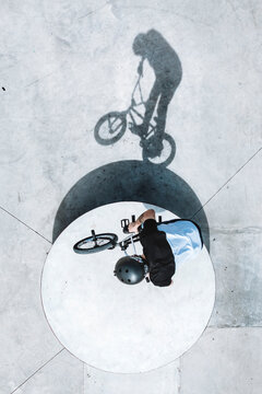 Aerial view of BMX bike rider silhouette shadow doing a jump on concrete element in skatepark in Panevezys, Lithuania.