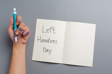 a woman left-hand with a pen.Left hander day concept.
