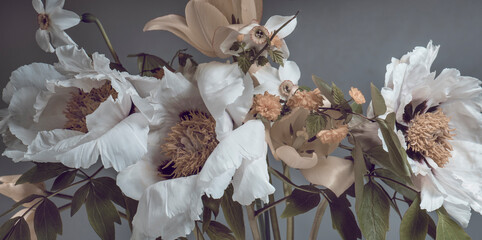 white peonies and spring flowers, a bouquet on a gray background.