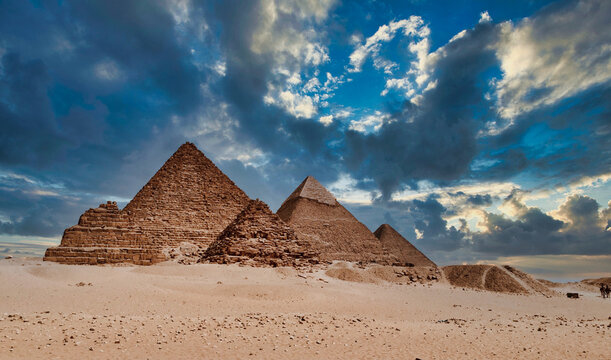 View Of Desert Against Cloudy Sky With Pyramid