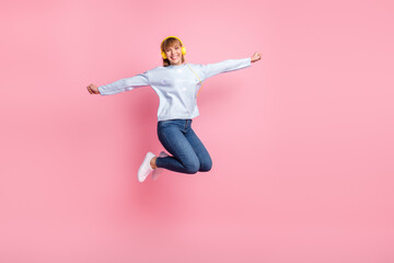 Fototapeta na wymiar Full length body size view of pretty cheerful girl jumping listening melody having fun isolated over pink pastel color background